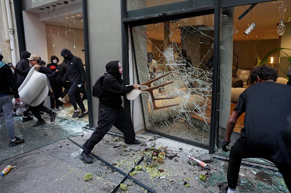 Protesters vandalise a retail store during a demonstration near Place de la République in Paris.