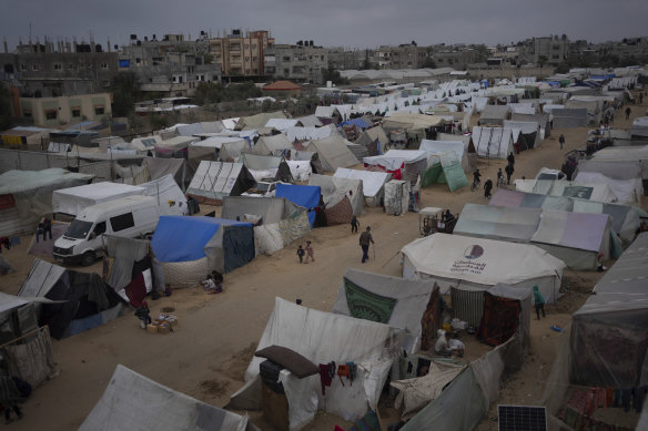 Palestinians displaced by the Israeli ground offensive on the Gaza Strip walk at the makeshift tent camp in Rafah.