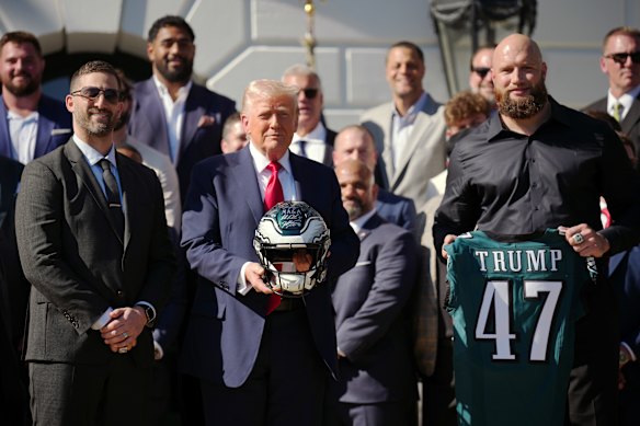 Trump poses with Philadelphia Eagles head coach Nick Sirianni (left) and player Lane Johnson at an event welcoming the 2025 Super Bowl champions.