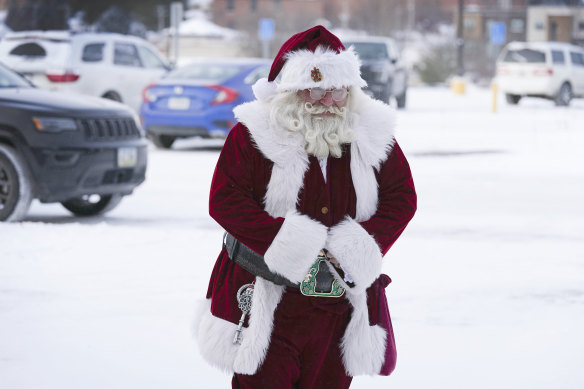 Arriving at a shopping mall in Iowa, Santa Dale makes his way through a snow-covered parking lot. Last name not given. 