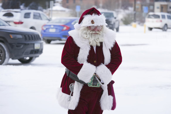 Santa Dale, no last name given, walks through a snow covered parking lot as he arrives at a mall iN Iowa. 