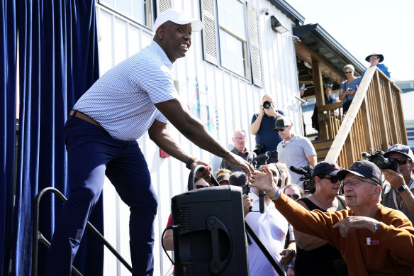 Republican presidential candidate Tim Scott greets audience members before speaking at the Iowa Fair.