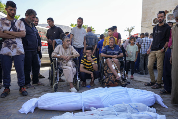 Wounded Palestinians attend a funeral for several people, including children, killed by Israeli bombardment of the Gaza Strip, in Deir al Balah, on Friday.