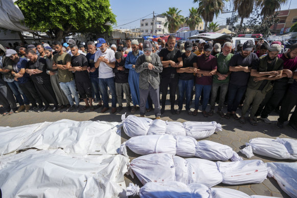 Palestinians mourn relatives killed in an Israeli strike on a UN-run school in the Gaza Strip.