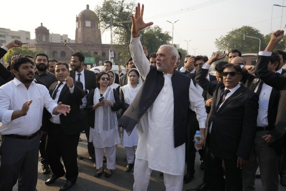 Imran Khan’s supported chant slogans while they block a road at a protest.