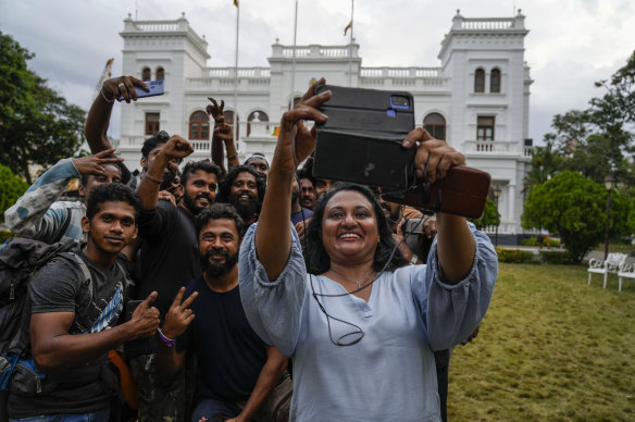 A woman takes a photograph outside the prime minister’s office in Colombo