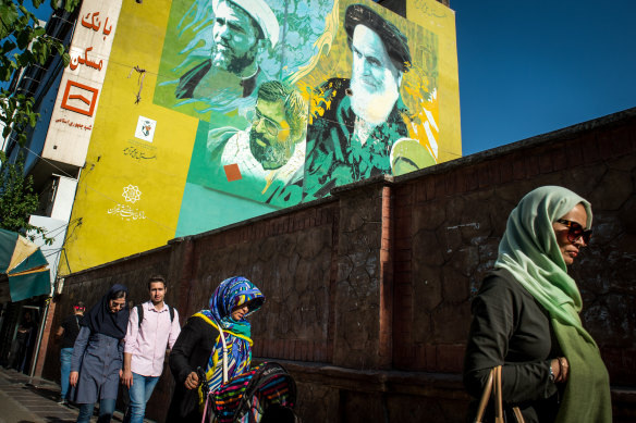 Pedestrians walk down the street in Tehran, Iran.