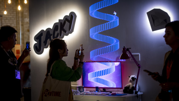 Attendees use smartphones to take photographs while viewing the YouTube story exhibit during the South By Southwest (SXSW) conference in Austin, Texas,  on Saturday.