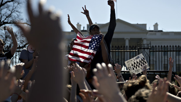 Students hold their hands up during a moment of silence during a protest against gun violence following the Florida massacre.