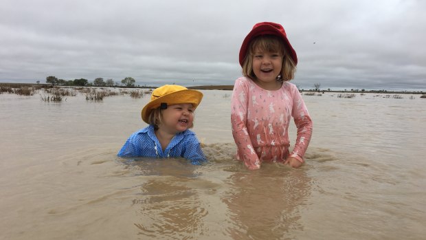 Two-year-old April Batt and her four-year-old sister Daisy Batt were nearly as happy as their parents when the creeks started to run muddy water at Hillview, Muttaburra after 50mm of rain on Saturday night.