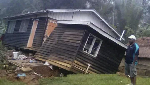 A man views a house that collapsed in the strong earthquake in Halagoli, Hela. PNG.