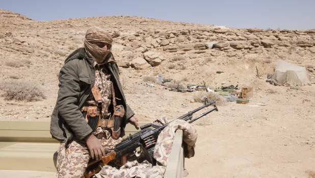 A Yemeni government fighter sits with his weapon on the back of a truck on the front line in the battle against Shiite-Houthi rebels outside Sanaa, Yemen.