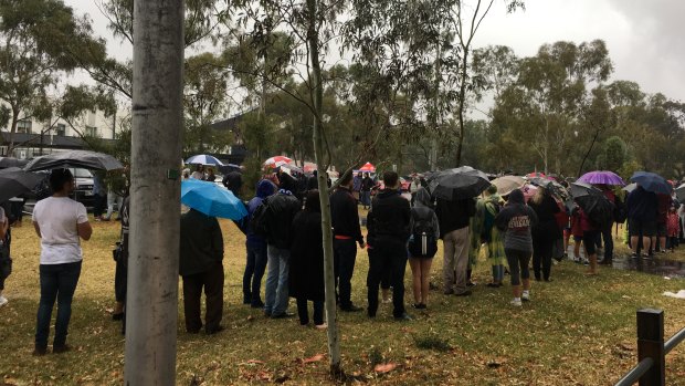 Diehard fans queued in the torrential rain for the AFLW grand final. 