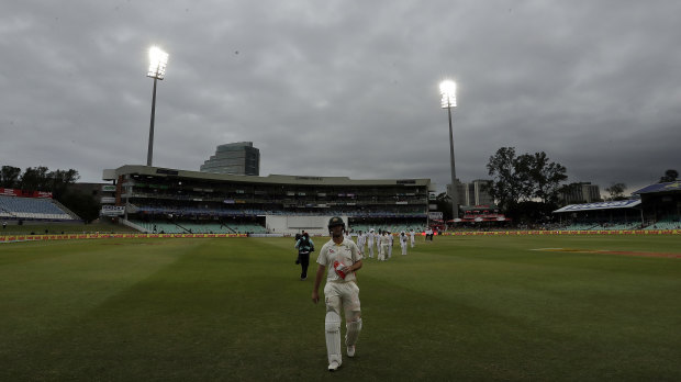 Australia's batsman Mitchell Marsh leaves the field as the match was delayed by bad light.
