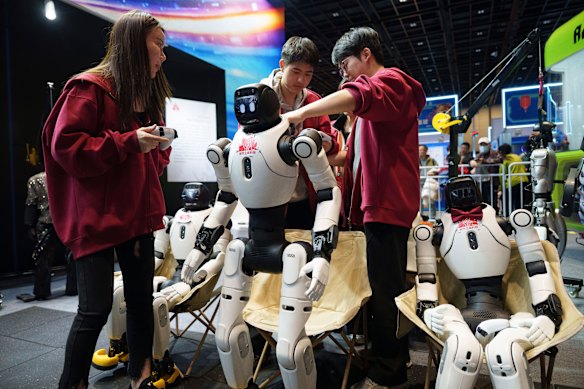 Workers prepare humanoid robots for a performance at a trade fair in Beijing, China, Wednesday, Feb. 18, 2026. 