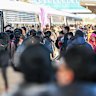 Commuters wait on the platform during the morning peak hour at Tarneit train station.