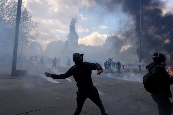 A protester throws a projectile during clashes with police in Paris on Saturday.