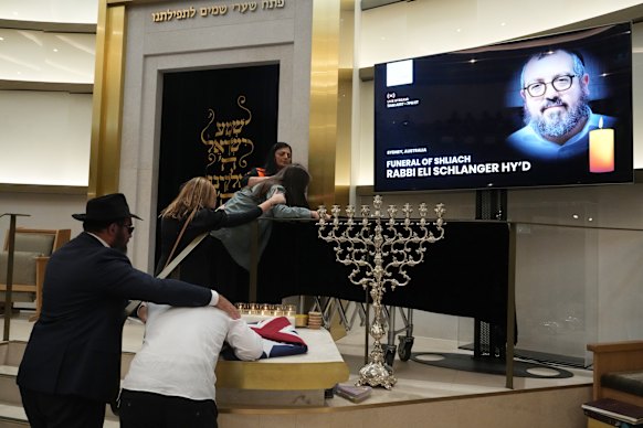 The air was heavy with anger and sorrow at Rabbi Eli Schlanger’s funeral.