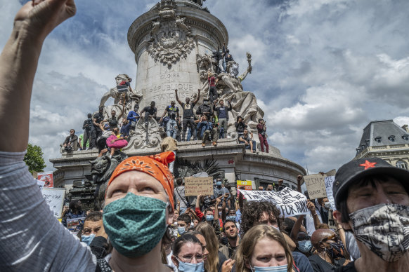 Anti-racism protesters stand on the monument in Place de la Republique in Paris on June 13.