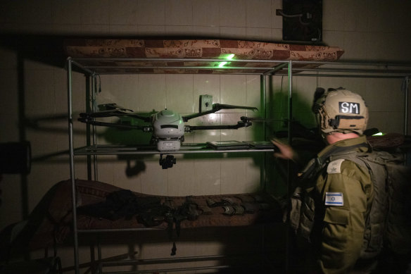 Israeli soldiers show a drone and weapons that they said were found on the grounds of Al Shifa Hospital in Gaza City.