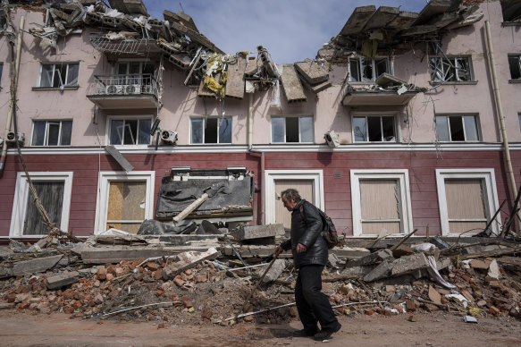A man walks past a building damaged by shelling in Chernihiv.