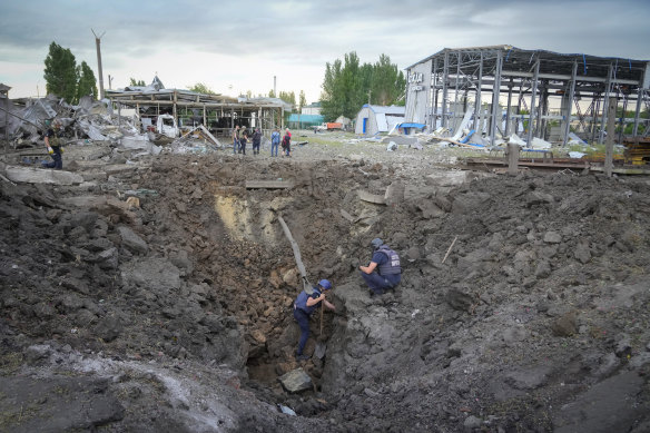 Police members inspect a crater caused by a Russian rocket attack in Pokrovsk, Donetsk region, Ukraine, on Wednesday.