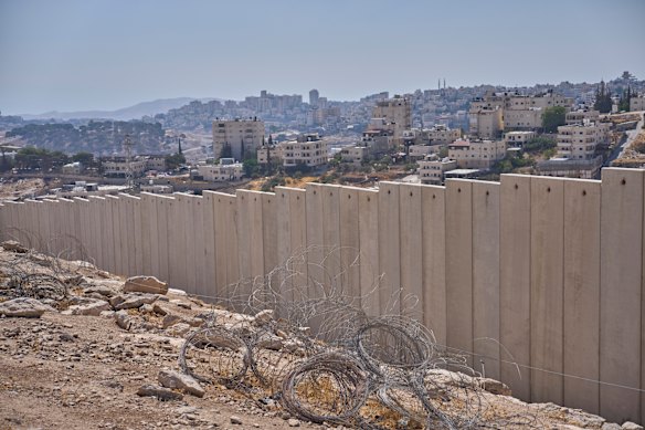 The separation wall next to the Arab neighborhood of Al-Eizariya, near where the Israeli government says housing units will be built as part of the E1 settlement development project.