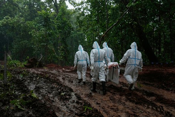 Nepalese military personnel carry a body to a burial site in Chitwan on Monday.