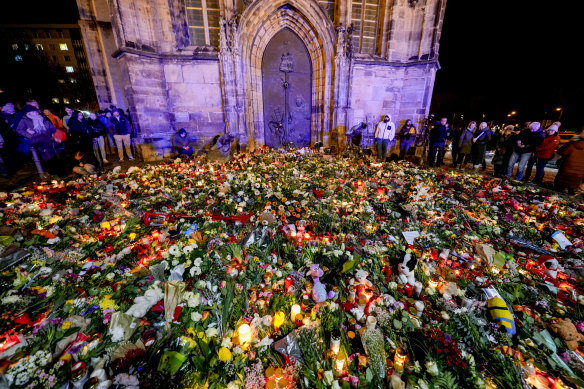 People have laid flowers and candles in front of the Johannis church close to the Christmas market, where a car drove into a crowd on Friday evening, in Magdeburg, Germany.