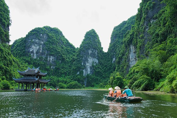 We paddle towards a temple in the middle of the limestone karsts in Trang An.