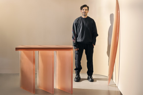 Surfboard designer Hayden Cox wearing pieces from his Haydenshapes apparel range, and his furniture collection for luxury Australian brand SP01. The console is $11,900 and the board is $3,950.