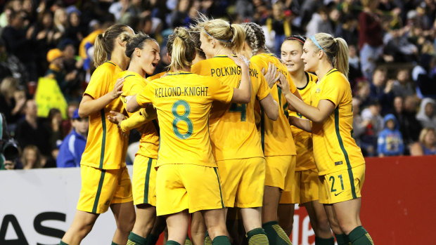 Right where she left off: Sam Kerr is mobbed by teammates after scoring for Australia.