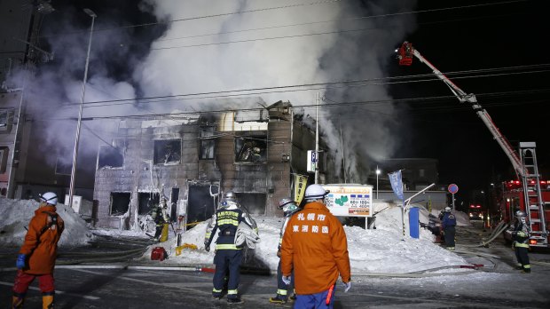 Firefighters work at the scene of the fire in Sapporo, northern Japan. 