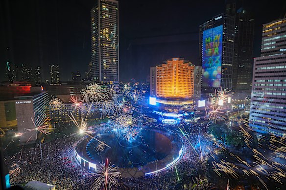 Fireworks explode as thousands of people gather to watch, in the main business district on New Year’s Eve in Jakarta, Indonesia.