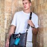Australian accessories label Oroton has relaunched its male accessories line. capitalising on the popularity of handbags for men. Model Russell White gives an Oroton bag the pub test in Redfern.