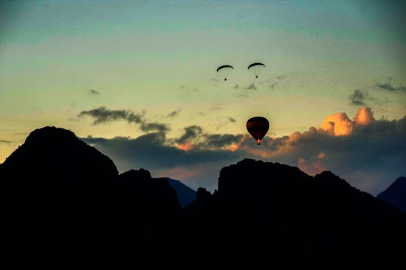 Foreign tourists ride on a hot air balloon in the sky in Vang Vieng, Laos, Saturday.