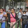 Workers wear masks as a protection against the spread of the new coronavirus as they leave from a day's work in Managua.