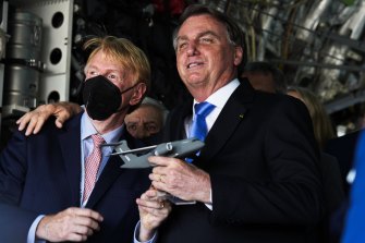 Brazilian President Jair Bolsonaro, right, embraces an official inside a Brazilian Air Force Embraer KC-390 at the Dubai Air Show in the UAE last week.