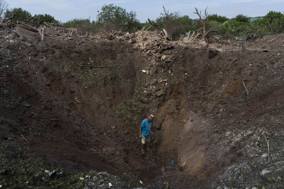 A resident walks into a crater caused by a missile strike in Druzhkivka, eastern Ukraine, last week.