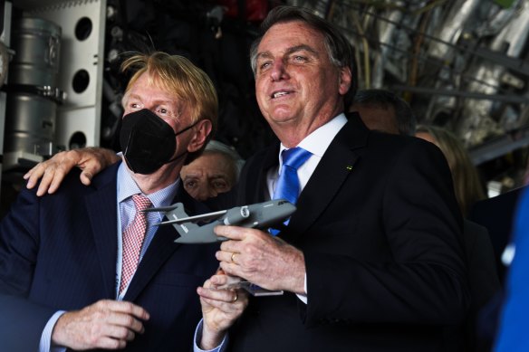 Brazilian President Jair Bolsonaro, right, embraces an official inside a Brazilian Air Force Embraer KC-390 at the Dubai Air Show in the UAE last week.