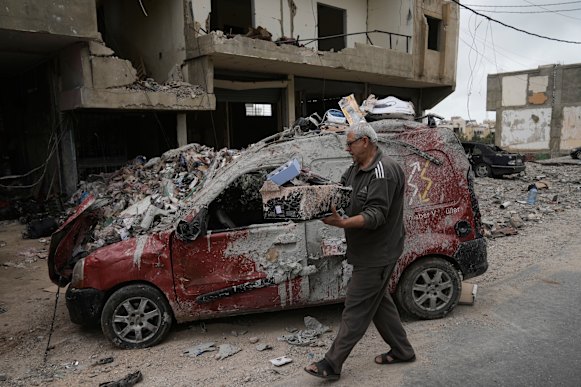 Mahmoud Ghadboun retrieves some of his belongings from a building destroyed in an Israeli airstrike.