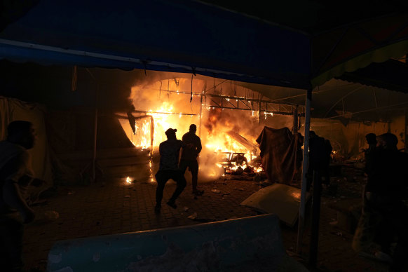 Palestinians react to a fire after an Israeli strike hit a tent area in the courtyard of Al-Aqsa Martyrs hospital in Deir al-Balah, Gaza Strip.  