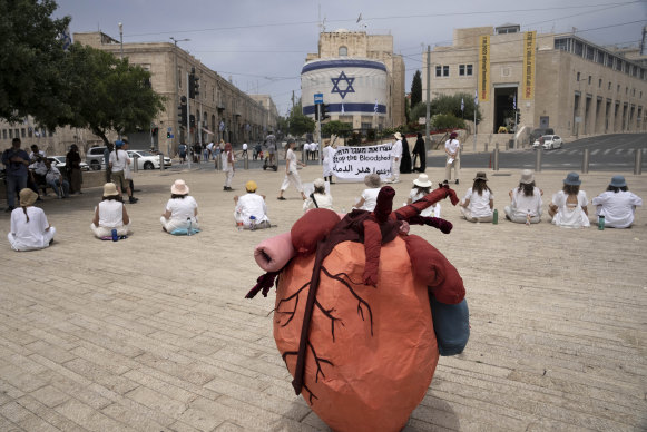 Women activists hold a silent protest with placards in Arabic, Hebrew and English calling for a ceasefire in the Gaza Strip and safety, freedom and equality for Israelis and Palestinians, outside the walls of the Old City of Jerusalem on Friday.