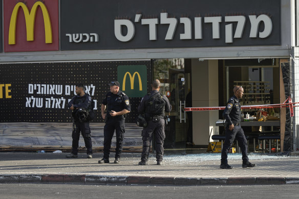 Police officers examine the scene of a stabbing and shooting attack where Israel’s Magen David Adom rescue service said one person was killed and several others were wounded in Beersheba.