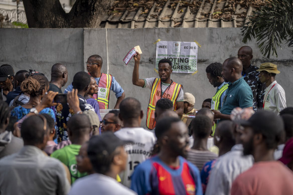 An electoral officer holds up votes as they are counted at a polling station in Lagos, Nigeria on Saturday.