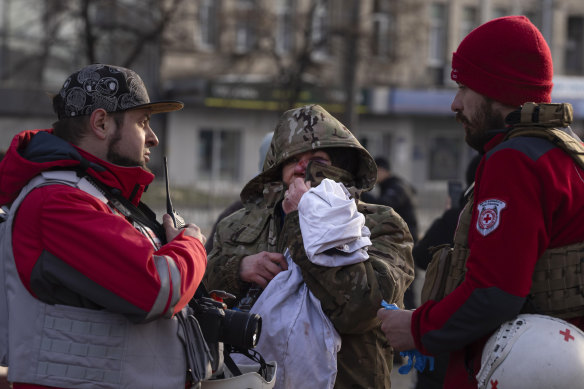 A wounded resident talks with paramedics after Russia’s missile attack in Kyiv on Friday.