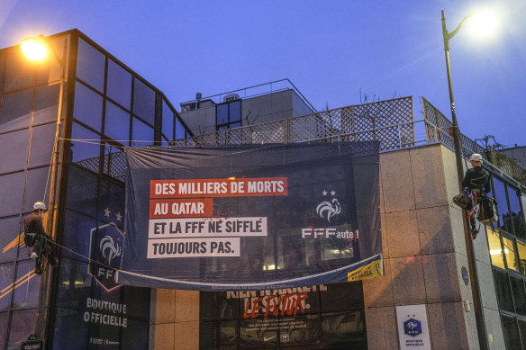 Amnesty International activists unfurl a banner on the building of the French soccer federation in Paris. It reads: “Thousands have died in Qatar and the football federation has not said a word.”
