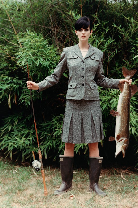 Model, Stella Tennant, wearing a grey tweed wool jacket and matching knee-length pleated skirt, by Anna Su.