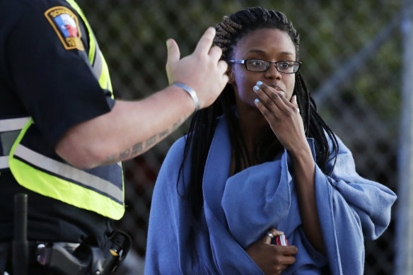 An employee wrapped in a blanket talks to a police officer after she was evacuated from the FedEx distribution centre.