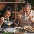 Helen Goh and Yotam Ottolenghi sharing dishes from the cookbook Comfort.